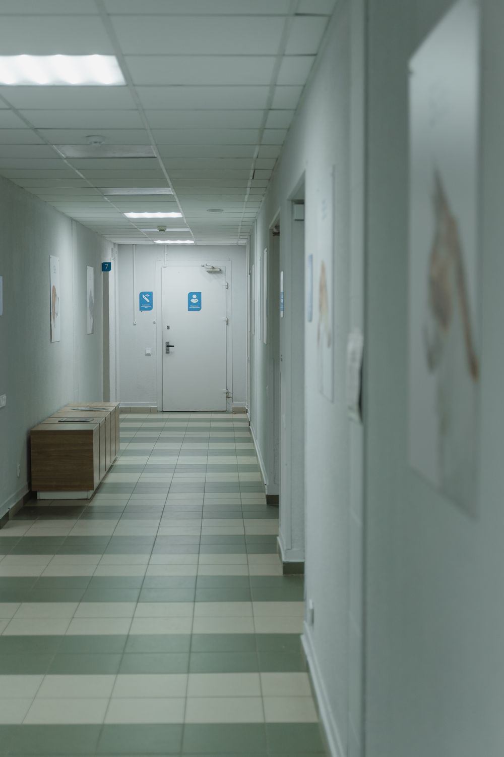 An empty clinic corridor with signage at the far end