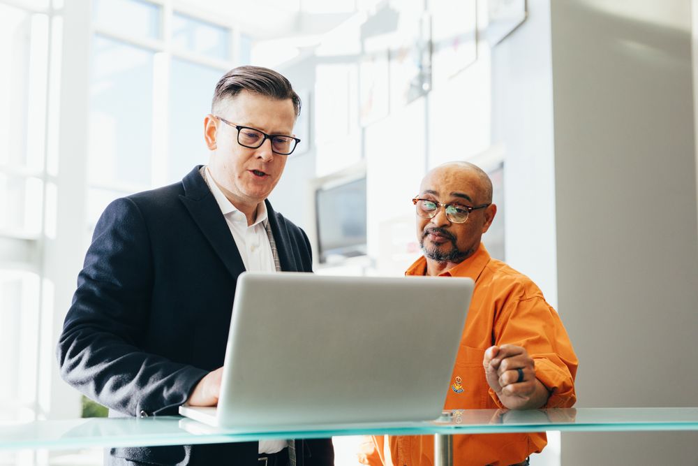 Two business owners reviewing their account together on a laptop