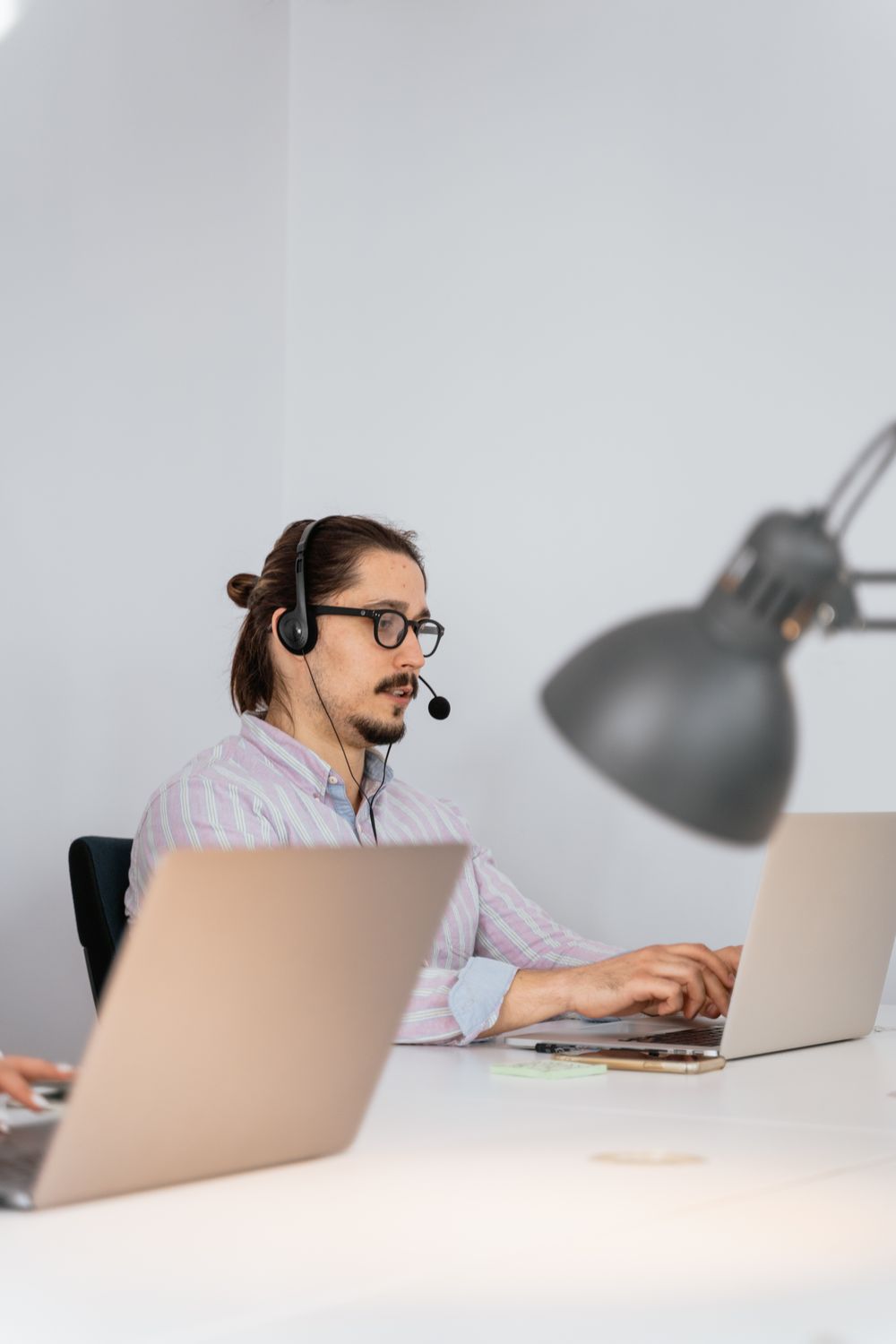 A ReliaRing support agent wearing a headset, working at a laptop